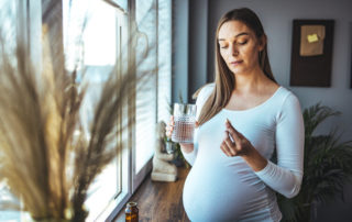 Schwangere Frau nimmt Tablette ein